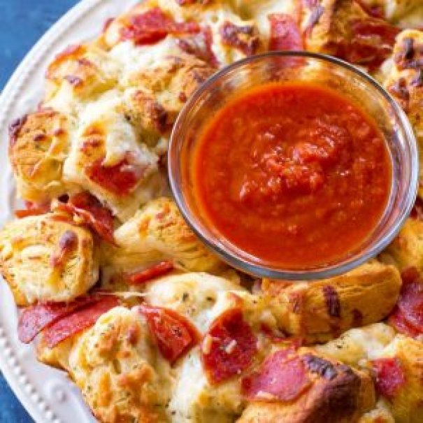Pizza Monkey Bread is an Italian appetizer stuffed with pepperoni, mozzarella cheese, and garlic all in a Bundt pan.  If you love pizza, you'll love this Pizza Monkey Bread made with biscuits and marinara sauce for dipping. 